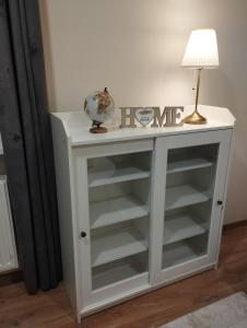 a white console table with a lamp on it at Havel Apartment in Opole
