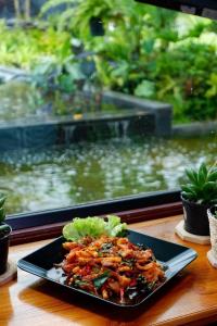 une plaque de nourriture sur une table devant un aquarium dans l'établissement Srihome ยายศรีโฮมแอนแคมป์ปิ้ง, à Ban Don Tum (1)