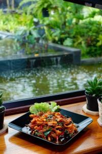 a plate of food on a table in front of a fish tank at Srihome ยายศรีโฮมแอนแคมป์ปิ้ง in Ban Don Tum (1)