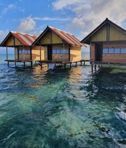 two overwater bungalows in the water in the ocean at Cabañas Waili in Niatupo