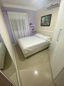 ein kleines Schlafzimmer mit einem Bett und einem Fenster in der Unterkunft Garden Ville, 200m da Praia de Bombas in Bombinhas