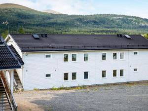 un bâtiment blanc avec un toit noir dans l'établissement 8 person holiday home in LOFSDALEN, à Lofsdalen