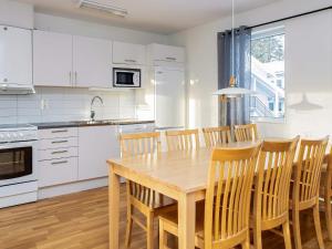 a kitchen with white cabinets and a wooden table and chairs at Apartment LOFSDALEN V in Lofsdalen