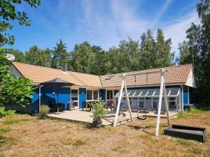 une maison bleue avec une terrasse couverte et une balançoire dans l'établissement Holiday home Nexø XLII, à Neksø