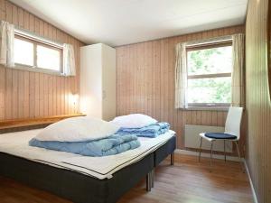 Un dormitorio con 2 camas y una silla. en Holiday home Nexø XLII, en Neksø