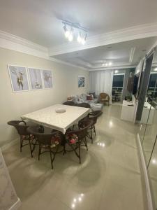 sala de estar con mesa, sillas y sofá en Garden Ville, 200m da Praia de Bombas, en Bombinhas