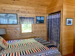 Clam Gulch Lodge في Clam Gulch: غرفة نوم مع سرير في كابينة خشب