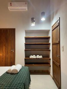 um quarto com uma cama com um cobertor verde e prateleiras em POUSADA IPIRÃTÃ - Turismo de Vivência Cultural em Soure