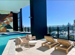 ein Haus mit einem Pool und zwei Stühlen in der Unterkunft ocean view 2 Bedrooms at Broadbeach in Gold Coast