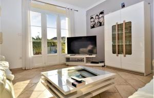 uma sala de estar com uma televisão e uma mesa de café em vidro em 3 Bedroom Nice Home In Jonquire Saint Vincen em Jonquières-et-Saint-Vincent