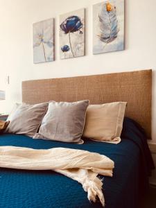 een bed met vier schilderijen aan de muur bij Departamento sobre el Rio. in Corrientes +3 foto's