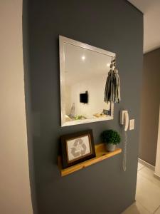 een badkamer met een spiegel en een foto op een plank bij Departamento sobre el Rio. in Corrientes