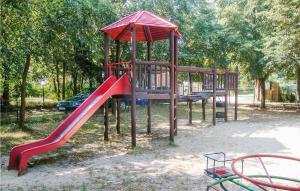 a playground with a red slide in a park at Cozy Home In Murowana Goslina With Kitchen in Brzeźno
