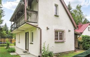 Una casa blanca con un balcón en el lateral. en Cozy Home In Murowana Goslina With Kitchen, en Brzeźno