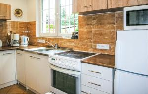 cocina con electrodomésticos blancos y nevera blanca en Cozy Home In Murowana Goslina With Kitchen, en Brzeźno