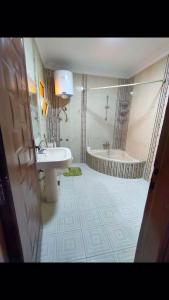 a bathroom with a sink and a bath tub at lovely 3 bedroom apartment with 2 balconies and a hot tub in Cairo