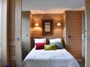 sypialnia z białym łóżkiem i kolorowymi poduszkami w obiekcie Duplex avec 4 chambres pour 10 à Méribel, proche pistes et commerces, parking inclus - FR-1-180-578 w mieście Les Allues +18 zdjęć