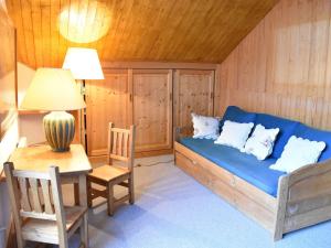 Pokój z niebieską kanapą, stołem i lampą w obiekcie Duplex avec 4 chambres pour 10 à Méribel, proche pistes et commerces, parking inclus - FR-1-180-578 w mieście Les Allues