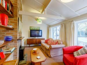 a living room with a couch and a tv at Hall Farm Bungalow in Shirley