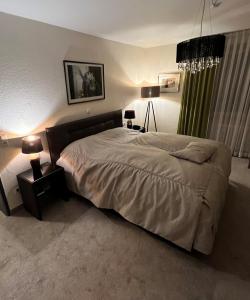 ミンデンにあるHotel Exquisitのベッドルーム(大型ベッド1台、ランプ付きテーブル付)