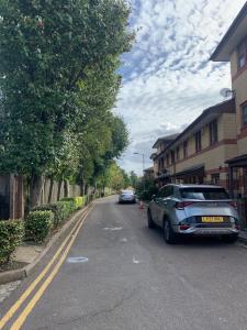 een auto geparkeerd aan de kant van een straat bij Large, Spacious 3 Bedroom Sleeps 6, Apartment for Contractors and Holidays in Lewisham, Greater London - 1 FREE PARKING SPACE & FREE WIFI in Londen