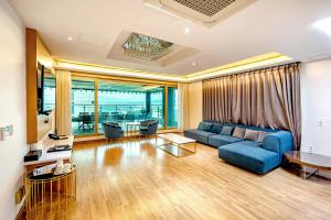 a living room with a blue couch and a table at HS Tourist Hotel in Yeosu