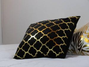 a black and gold pillow sitting on a bed at Vamos para Bello Antioquia in Bello