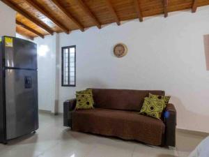 een woonkamer met een bank en een koelkast bij Vamos para Bello Antioquia in Bello