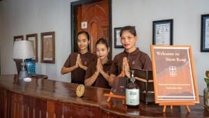 a group of people standing at a counter with their hands up at DEN HOTEL TOTONOU SIEM REAP in Siem Reap