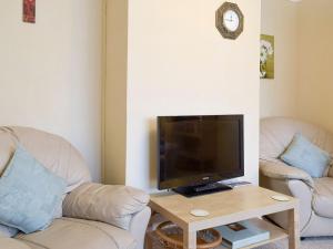 sala de estar con 2 sillas y TV de pantalla plana en Lenas Lodge en Birtsmorton