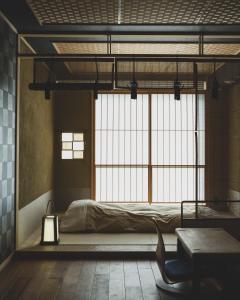 sypialnia z łóżkiem i dużym oknem w obiekcie cyashitsu ryokan asakusa w Tokio