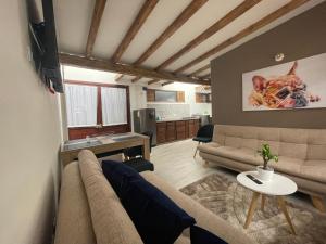 a living room with a couch and a dog on the wall at PUERTA DE LA VILLA Apartamentos y Habitaciones in Villa de Leyva
