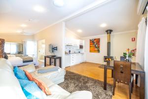 a living room with a white couch and a desk at Camelot Boutique Accommodation in Mount Tamborine