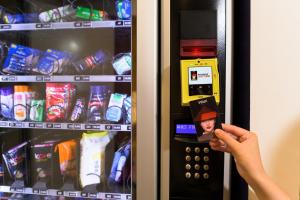 uma pessoa está tirando uma foto de uma máquina de venda automática em Wink Hotel Danang Centre - 24hrs stay em Da Nang