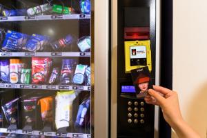 a person is taking a picture of a vending machine at Wink Hotel Danang Centre - 24hrs stay in Danang