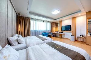 a hotel room with two beds and a television at HS Tourist Hotel in Yeosu