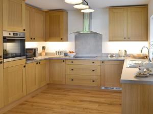 a kitchen with wooden cabinets and stainless steel appliances at Robin Cottage - Ukc3436 in Newton Abbot