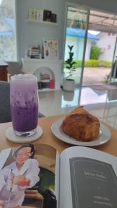 a book and a drink and a pastry on a table at Anyamanee Resort Trat in Trat