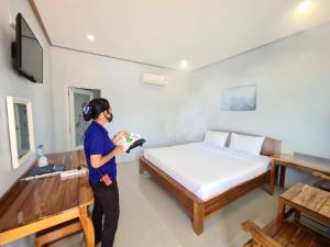 Anyamanee Resort Trat في ترات: امرأة تقف في غرفة مع سرير