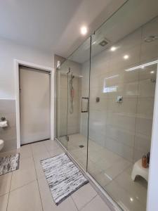 a bathroom with a shower and a glass shower stall at The perfect getaway for two in a large suite in Whanganui