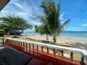 a view of the beach from the balcony of a house at Rainbow Bungalow Haadrin Koh Phangan in Haad Rin