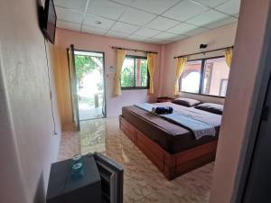 哈林海灘的住宿－Rainbow Bungalow Haadrin Koh Phangan，一间卧室配有一张床和一台电视。
