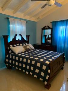 a bedroom with a bed with a mirror and blue walls at PARADISE VILLa 2 PRIVATE POOL in Ocho Rios