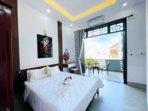 Schlafzimmer mit einem Bett mit weißer Bettwäsche und einem großen Fenster in der Unterkunft Full House Homestay in Hue