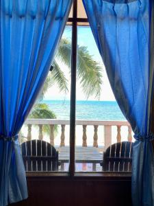 una ventana con vistas al océano desde un complejo en Rainbow Bungalow Haadrin Koh Phangan, en Haad Rin