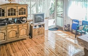 ein Wohnzimmer mit einem TV und Holzschränken in der Unterkunft 2 Bedroom Cozy Home In Brenno in Brenno