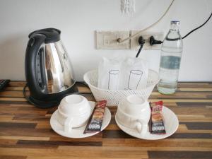 a counter with two cups and a coffee pot and a bottle at Fang Villa Hotel in Fang