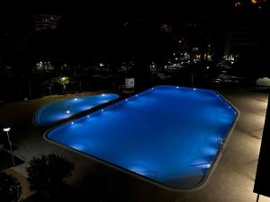 a large swimming pool at night with blue illumination at BEACH & URBAN PLAYA SAN JUAN in Alicante