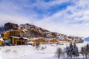 a resort in the snow with snow covered buildings at Zona Portici in Prato Nevoso