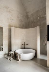 a white bath tub in a bathroom with a ceiling at Melisende in ‘Akko